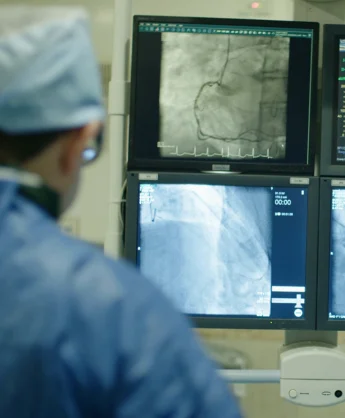 A cardiologist reviewing coronary angiography images in the catheterisation laboratory