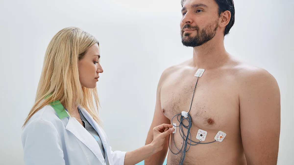 Clinician fitting Holter monitor electrodes to a patient